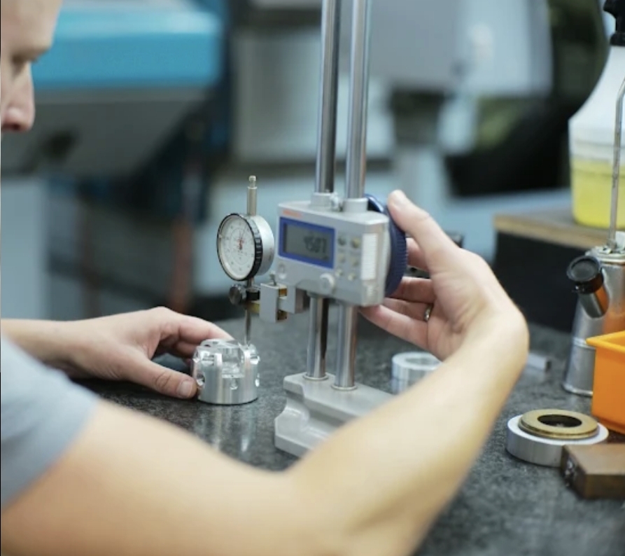 Prüfung eines gefertigten Aluminiumteils mit Messuhr